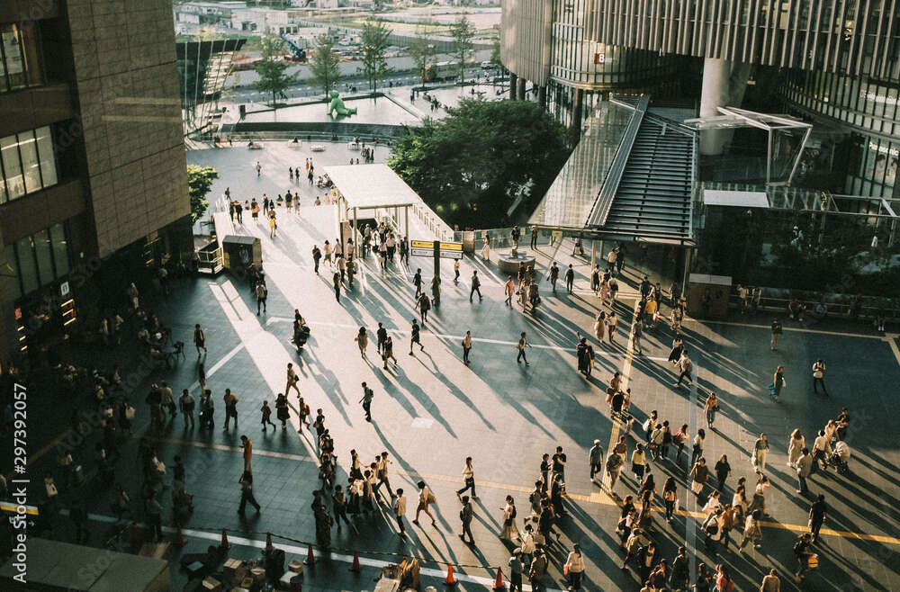 Directly above view of pavement with people walking towards buildings
