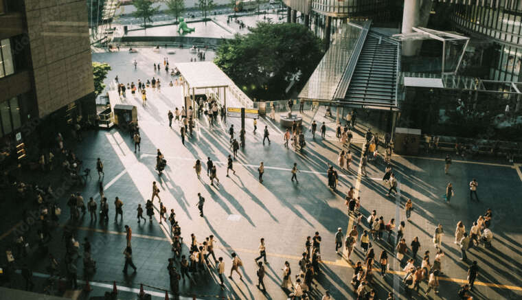 Directly above view of pavement with people walking towards buildings